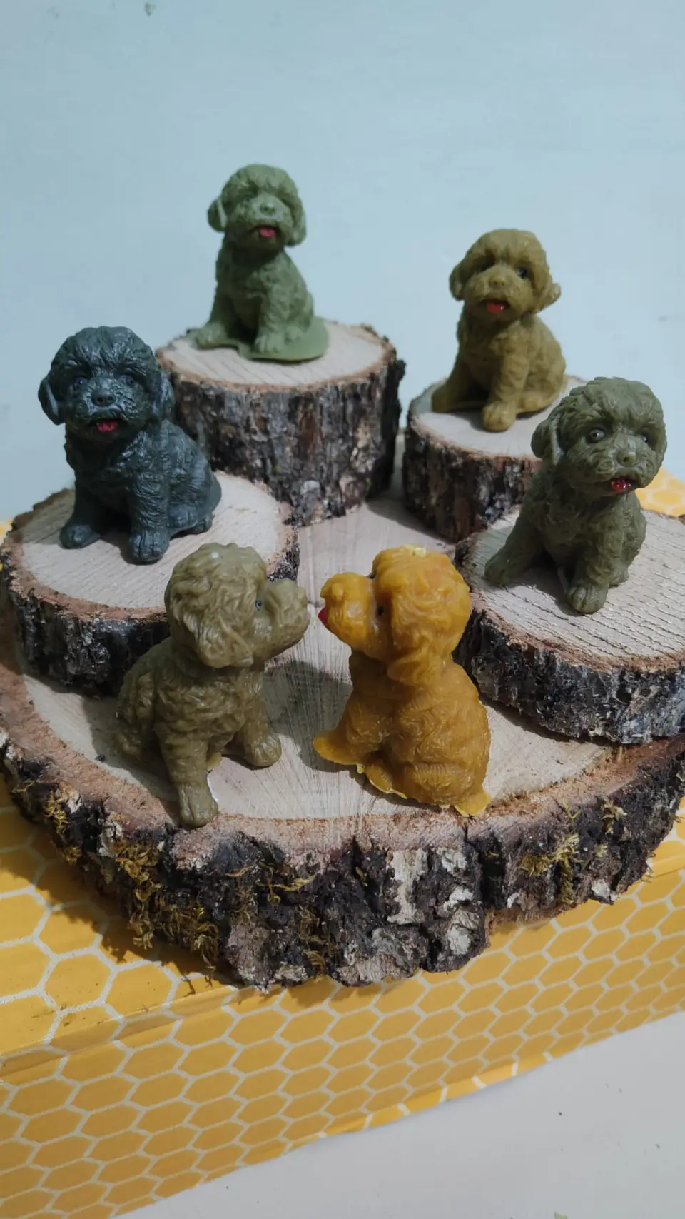 Piccoli cagnolini in cera colorata su fette di tronco