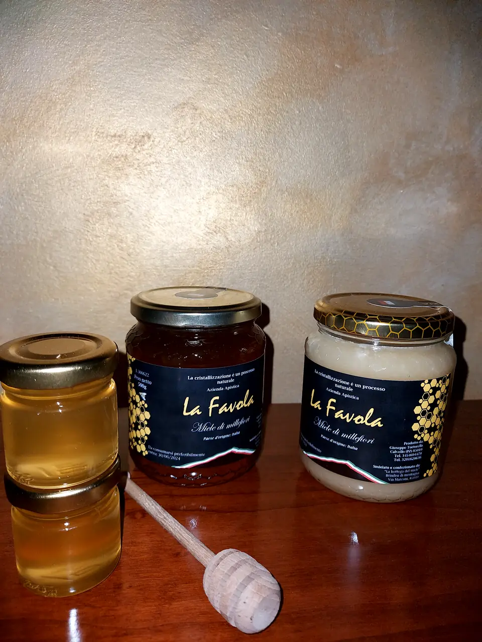 Vasetti di miele La Favola su un tavolo con mestolino